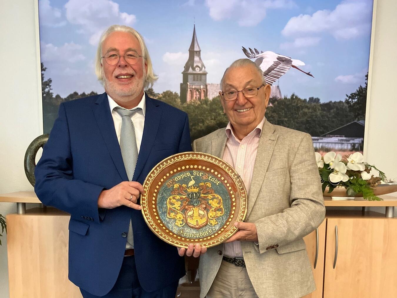 Bürgermeister Ferdi Böhmer (l.) freut sich über das besondere Geschenk von Heinz Hüttges (r.). Foto: Gemeinde Kranenburg
