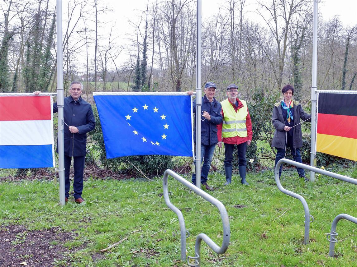 Bürgermeister Hans Teunissen (Gemeinde Gennep/NL), Sjaak Kamps, der ehemalige Direktor der Euregio Rhein-Waal, Antoon Rodoe (HVV Hommersum) und Maria Beaupoil, Vertreterin des Gocher Bürgermeisters (v. l.), hissten gemeinsam die niederländische und deutsche Flagge und die Europaflagge. NN-Foto: Gerhard Seybert