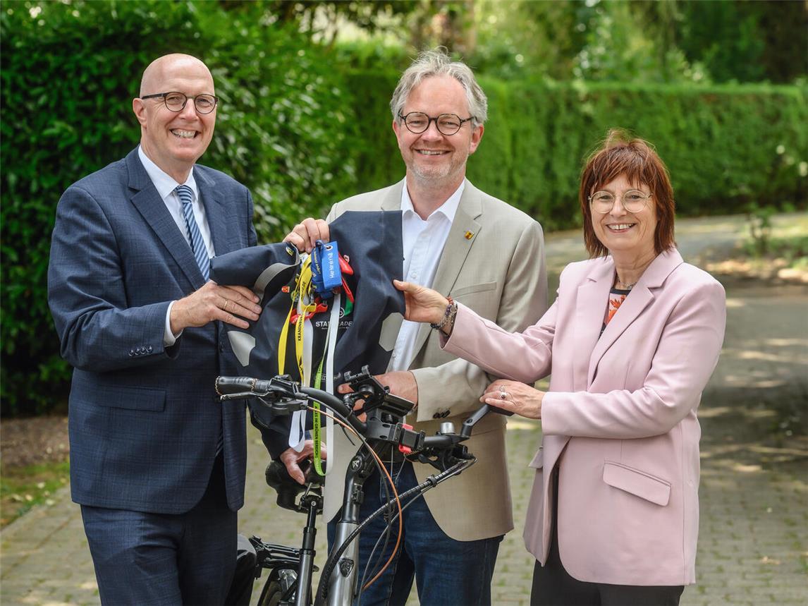 Bürgermeister Paul Hoene überreicht die Staffeltasche an Landrat Christoph Gerwers (l.) und Brigitte Jansen.Foto: Markus van Offern / WfG Kreis Kleve