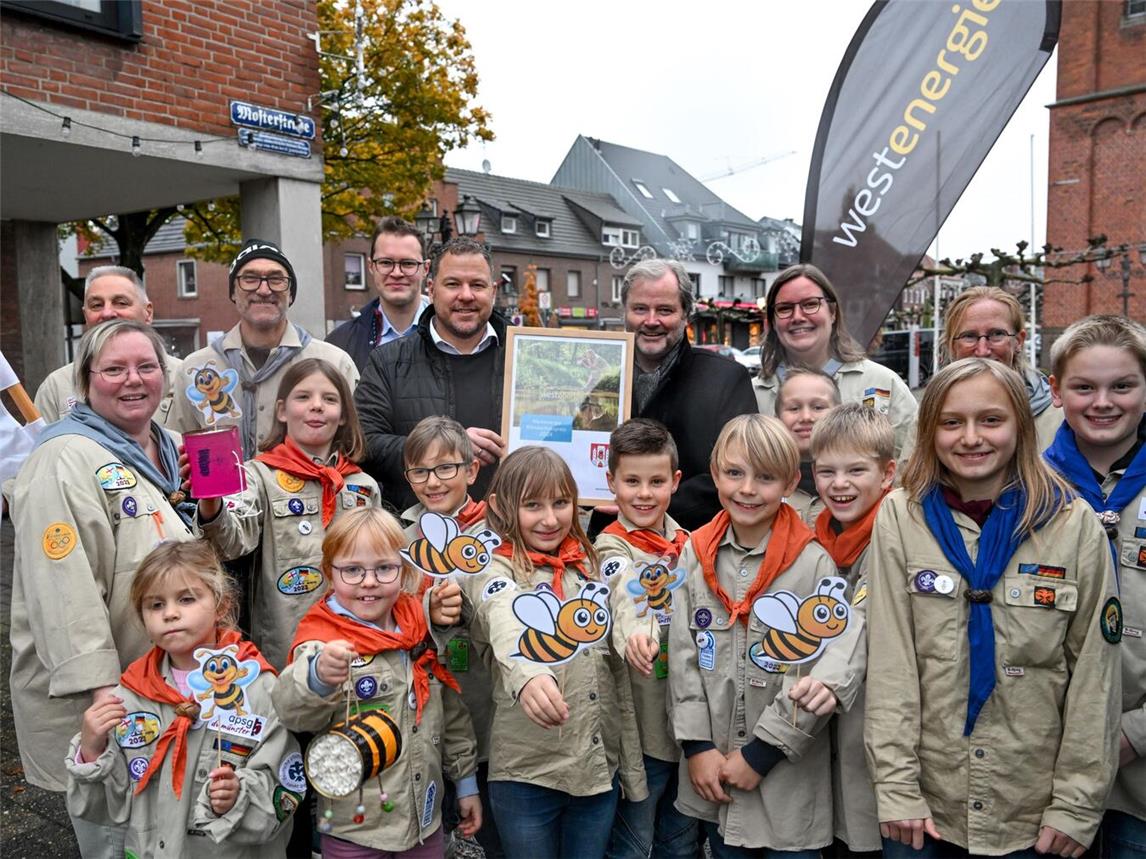 Bürgermeister Rainer Weber (letzte Reihe, 3. v. r.), Sebastian Okon, Klimaschutzmanager der Gemeinde Uedem (letzte Reihe, 3. v. l.), und Nils Rudolph, Westenergie-Kommunalmanager (letzte Reihe, 4. v. l.) überreichten den Preis persönlich an die Pfadfinder. Foto: Westenergie