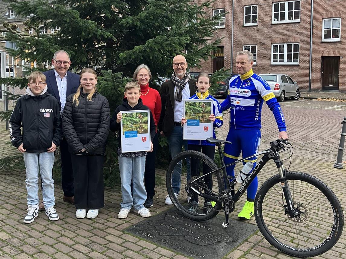 Bürgermeister Sebastian Hense (l.) und Dirk Krämer (Westenergie, 2. v. r.) gratulieren Lehrerin Sabine Bussmann (M.) und Volker Maas (r.) von der Radsportgemeinschaft Haldern zu ihrer Prämierung. Foto: Westenergie