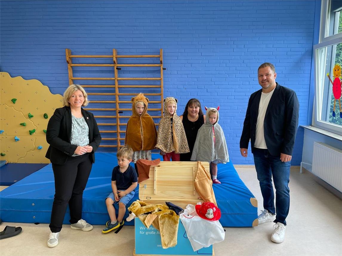 Bürgermeisterin Nadine Bogedain (l.) übergab den Verkleidungsspaß gemeinsam mit Nils Rudolph, Westenergie-Kommunalmanager (r.) an die Kindergartenkinder in der katholischen Kindertagesstätte St. Georg in Sonsbeck-Labbeck und Jennifer Janssen, Leitung der Kindertagesstätte (hinten r.). Foto: Westenergie AG