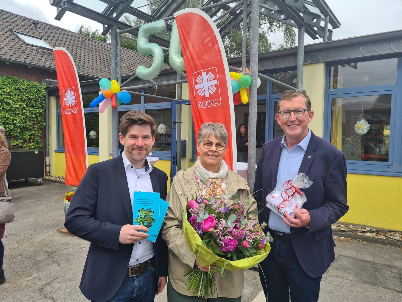 Caritasvorstand Karl Döring (r.) und Gerrit Hermans, Bereichsleiter Soziale Dienste, gratulieren Kita-Leiterin Cäcilia Horlemann zum 50-jährigen Jubiläums des Sprachheilkindergartens Pont.Foto: Caritasverband Geldern-Kevelaer