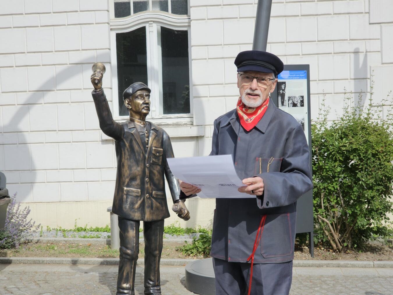 "Carlo Hofmann ehrt Heinrich Graeven mit Platt-Bekanntmachung bei Statue-Übergabe, Alpens Tradition."