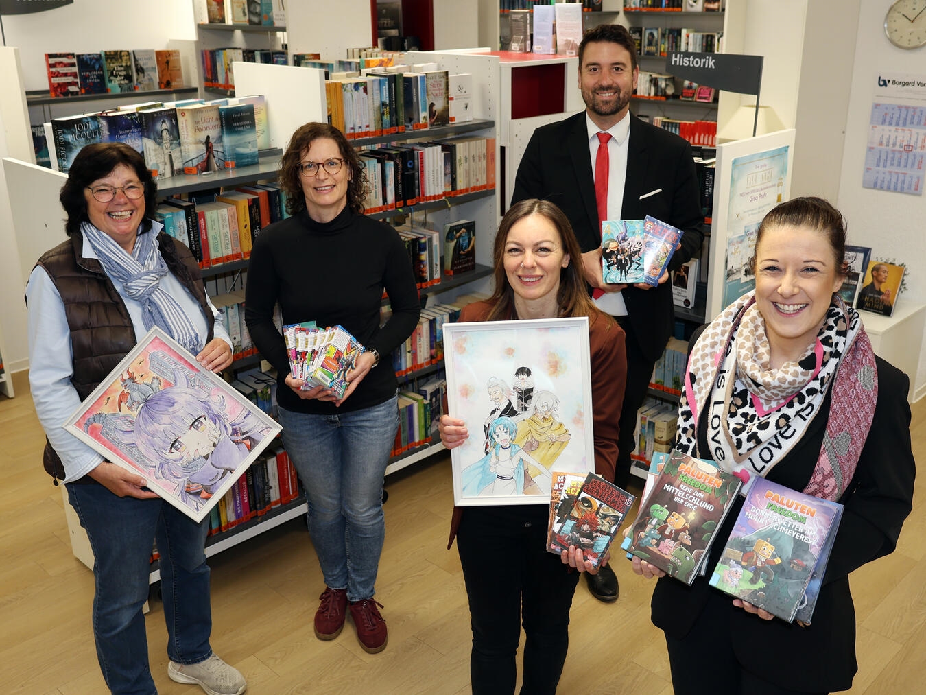 Christel Gembries, Nadine Meier und Nicole Militz freuen sich mit Sandra Bindl über neue Mangas dank 500-Euro-Spende der Sparkasse.