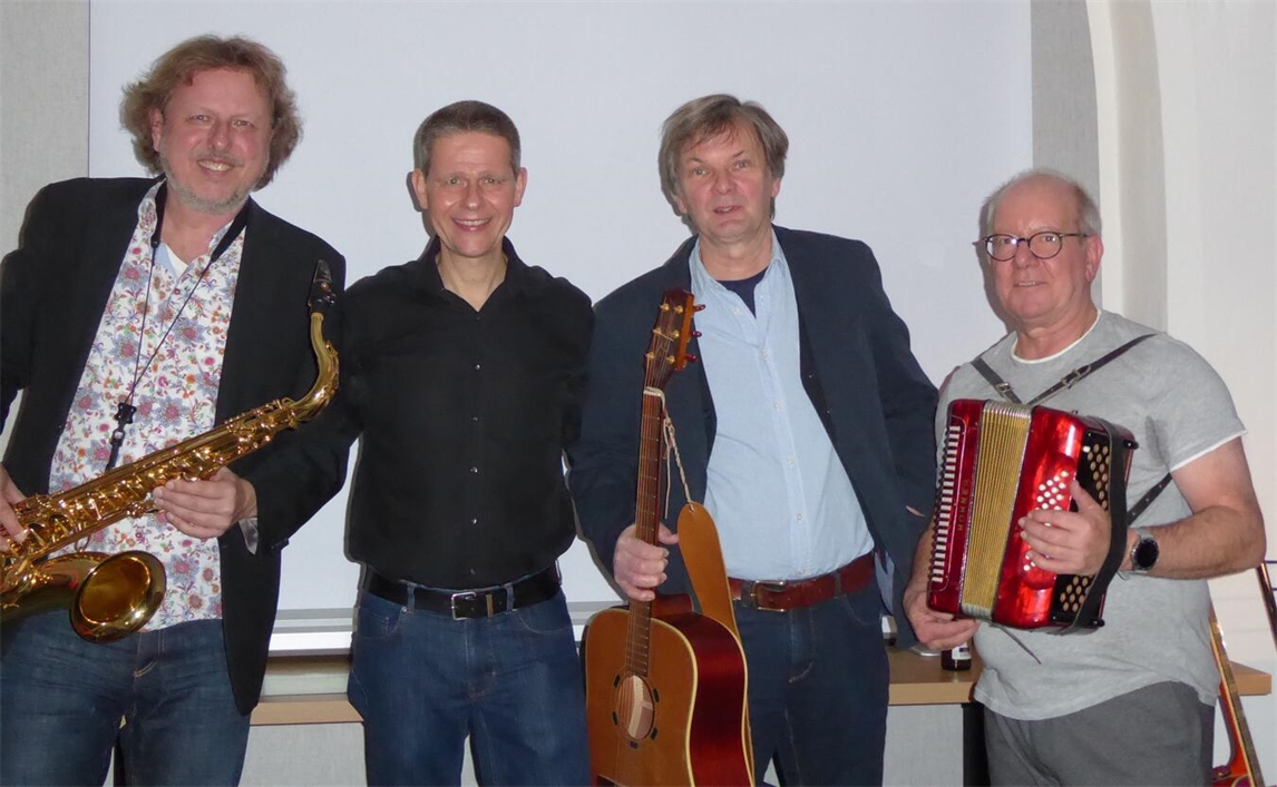 "Christian Behrens, Wilfried Schönherr, Volker Vienken und Volker Streck bei einem Treffen, lächelnd in die Kamera schauend."
