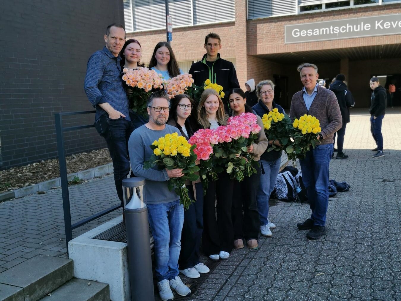 Christoph Feldmann und Martina Boudewins mit Schülerinnen und Rosen, Gewinnübergabe durch Thorsten Stern und Marcus Trappe.