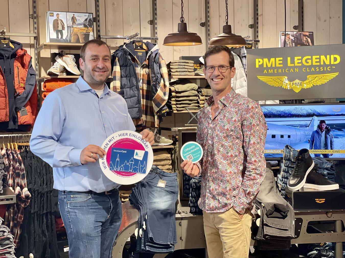 Citymanager Tobias Nelke und Markus Kaenders, Inhaber des Modehaus Kaenders bei der Einrichtung der neuen Verkaufsstelle. Foto: © Wallfahrtsstadt Kevelaer