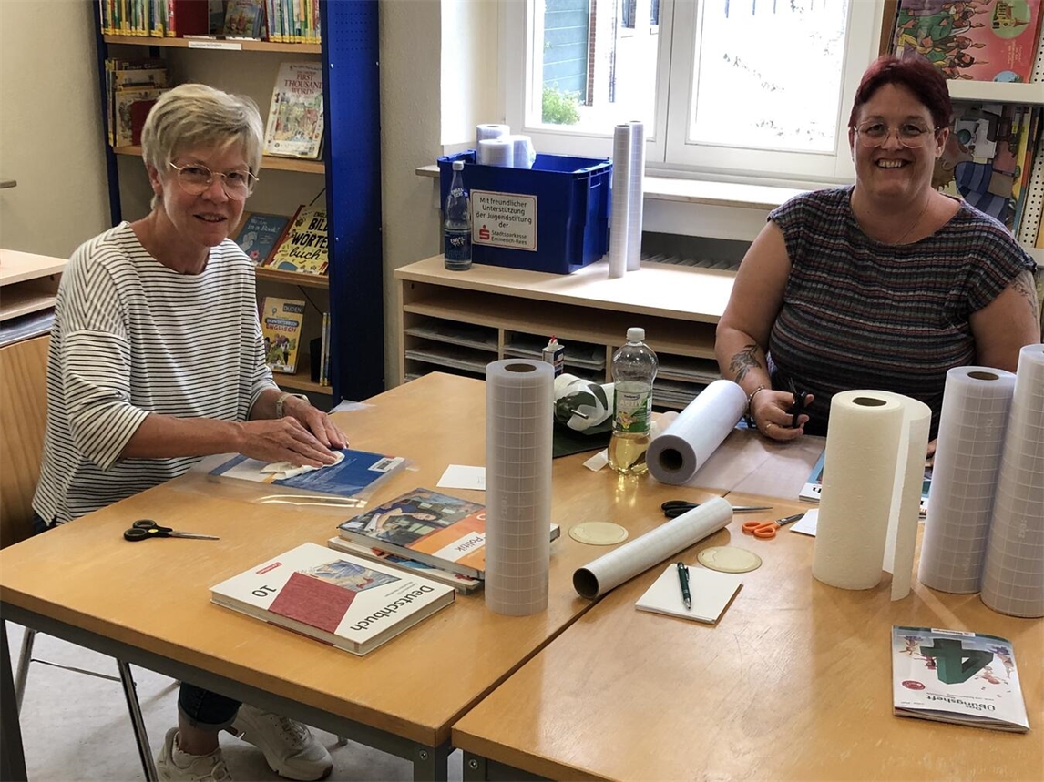 "Claudia Breuer und Verena Giesen binden neue Schulbücher ein, Büchereiteam Stadt Rees"