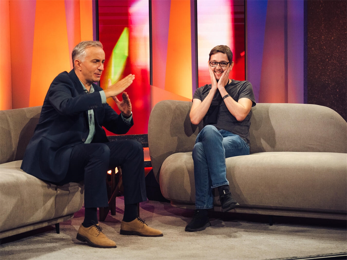 Daniel Schachtmeier (r.) neben Jan Böhmermann (l.) auf der Couch der ZDF-Sendung "Lass dich überraschen!". Foto: ZDF/Ben Knabe