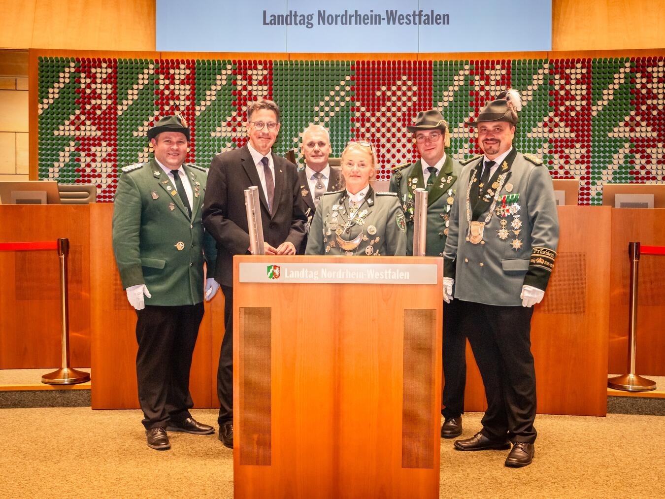 Das Bild zeigt (von l.) Michael Susen, Brudermeister der St. Evermarus Schützenbruderschaft, den Landtagsabgeordneten René Schneider, Michael Lisken vom St. Sebastianus Bezirksverband Moers, Conny Gerritz, Brudermeisterin der St. Bernhardus Bruderschaft Rossenray, Marcel van de Sand, Präsident des Bürgerschützenvereins Spellen sowie Andreas Blumenstengel, Präsident des Bürgerschützenvereins Orsoy, im Plenarsaal des NRW-Landtags. Foto: Chrisi Stark