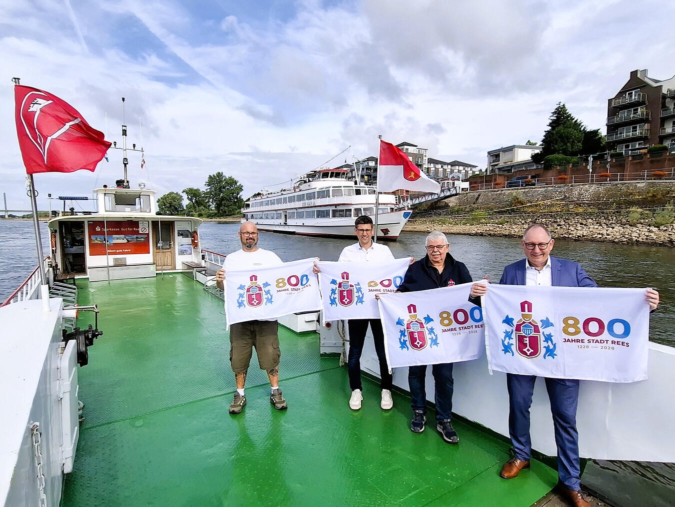 Fahrgastschiff „Germania“ und Rheinfähren mit Fahnen zum 800-jährigen Reeser Stadtjubiläum, Bürgermeister bei Übergabe der Fahnen.