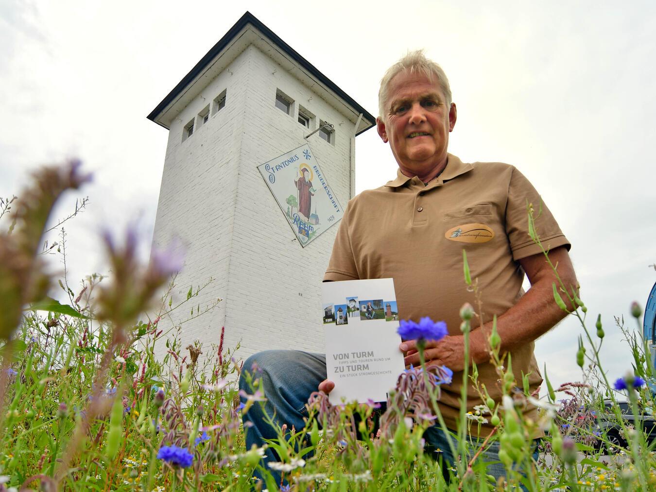 Das Foto zeigt Michael Sonfeld mit seinem Turmbuch vor dem Turm in Kerken-Stenden. Foto: privat