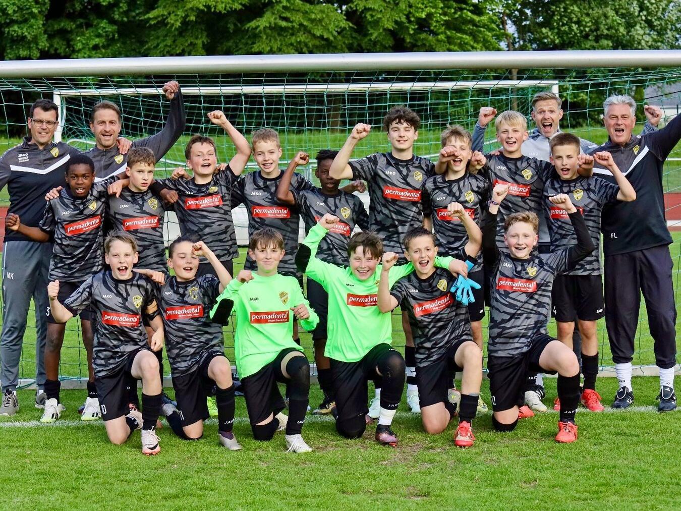 Das Meisterteam der JSG D1: (stehend v. l.) Joel Ikechukwu, Noah Vedder, Ben Heimann, Arne Nyland, Addo Owuso, Bennet Wagner, Mats Schnickers, Leo Rosendahl, Finn Schnickers; (kniend v. l.) Paul Heiting, Mikail Geurtsen, Robin Steinvoort, Lion Nieborg, Anton Berntsen, Jacob van Rothenburg; das Trainerteam: (v. l.) Marco Köster, Frank Steinvoort, Simon Berntsen und Friedhelm Langanke. Foto: Jan Ludwig