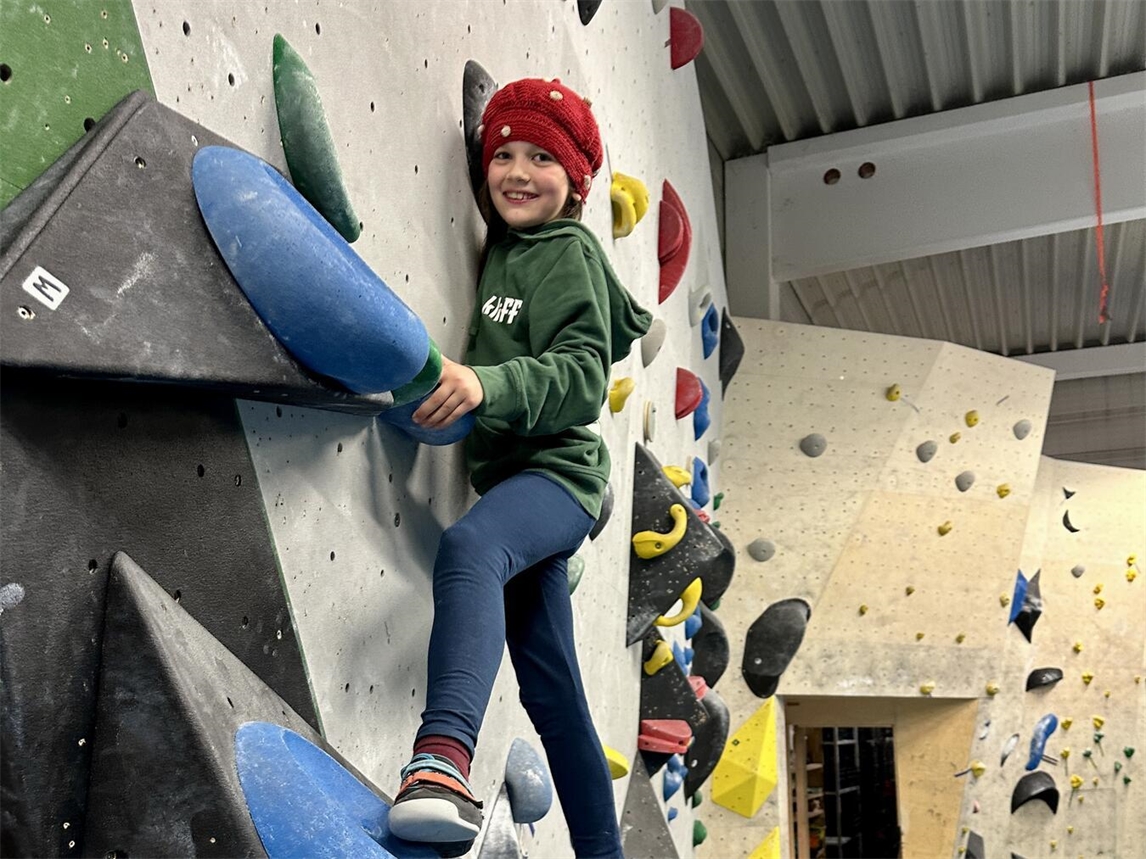"Kind beim Klettern in der Kliff Boulderhalle, geeignet für Anfänger, zweieinhalbstündiges Programm"