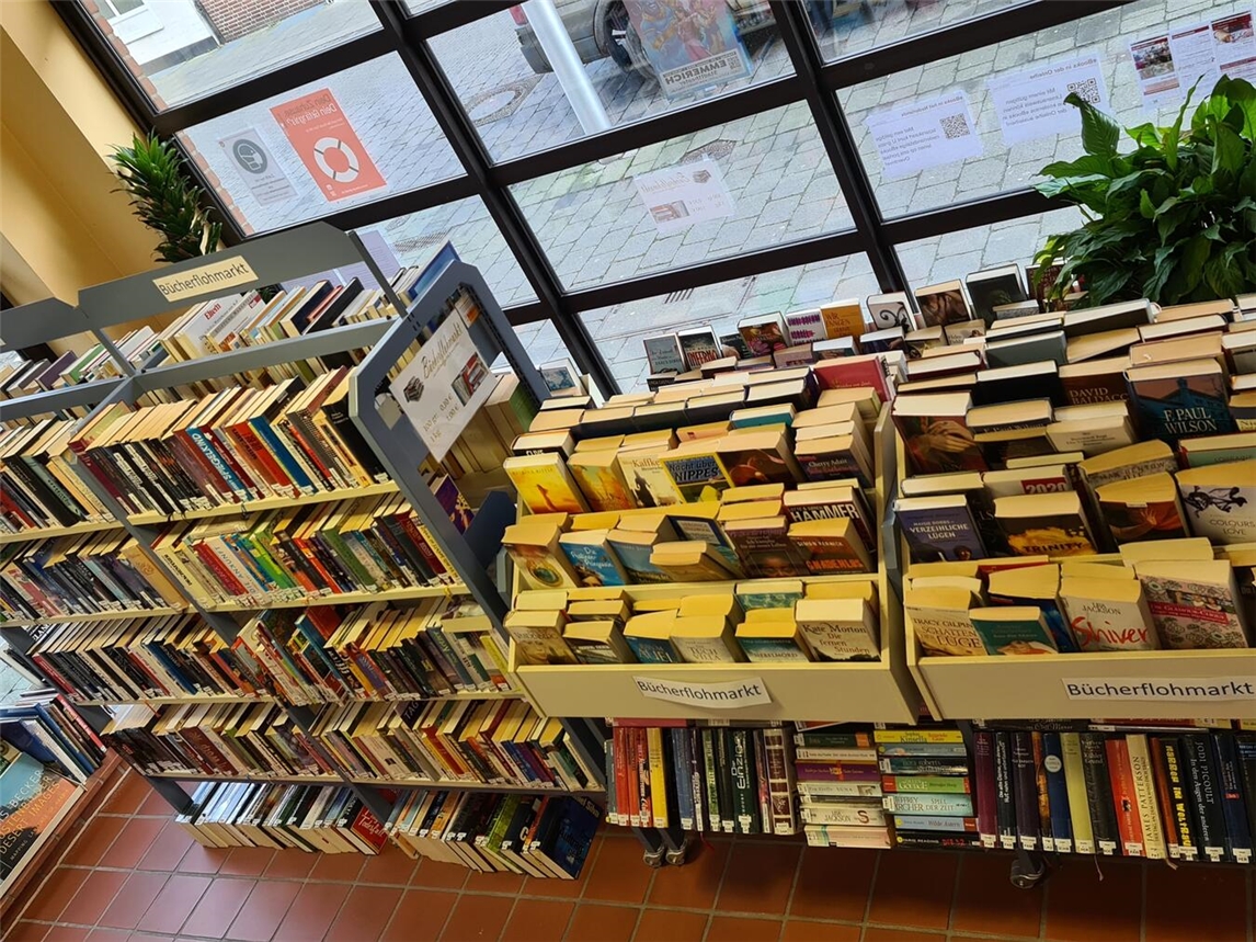 "Menschen stöbern beim Medienflohmarkt der Bücherei Emmerich, organisiert vom Förderverein, 17.-18. Juli"
