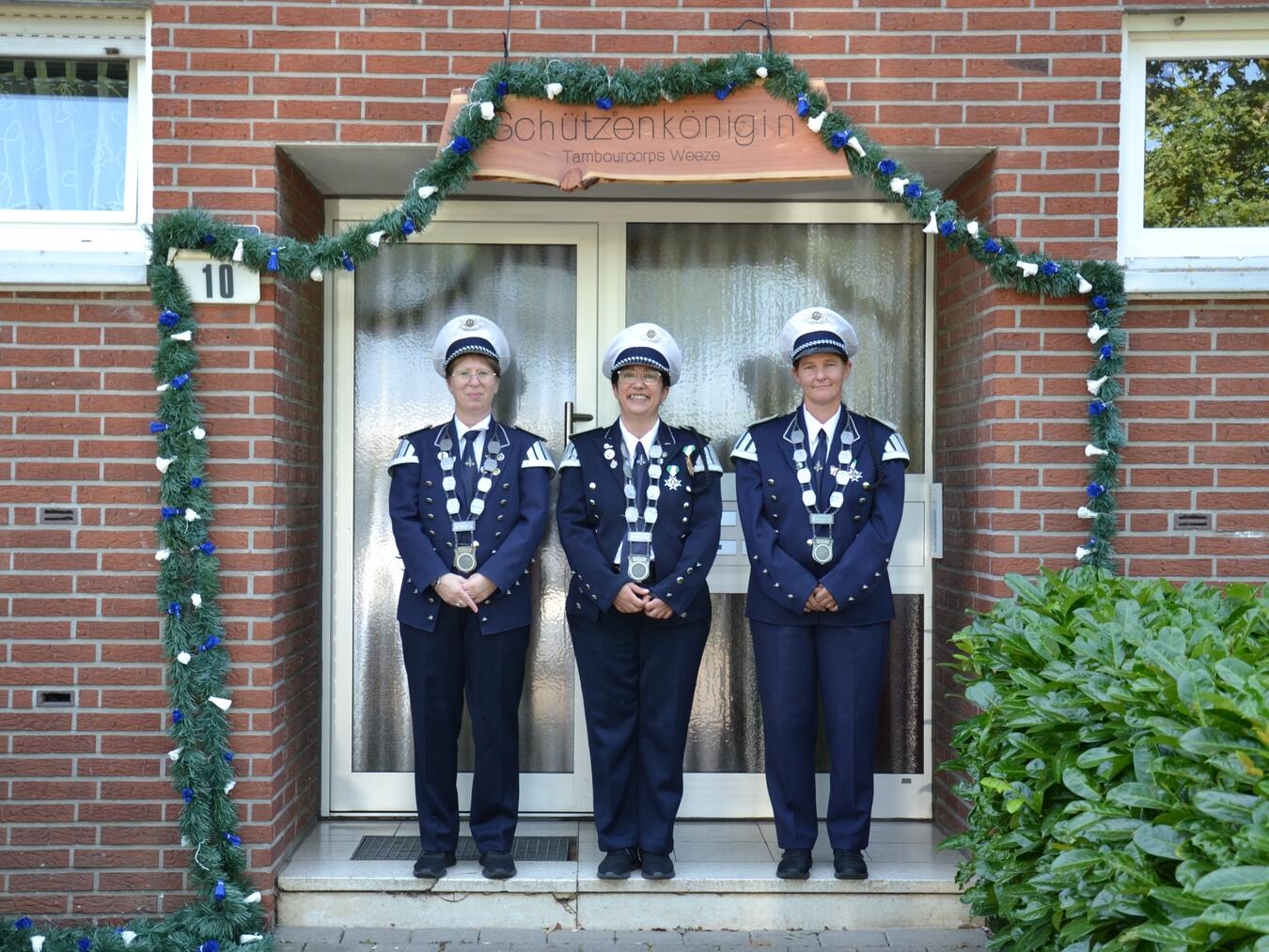 "Adjutantin Melanie Popowski, Königin Miriam ul Haq und Adjutantin Kathryn Knechten beim neuen Thron, Gruppenfoto, privat"