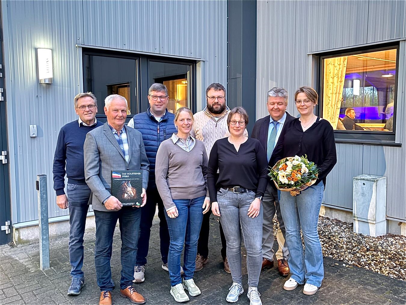 Gruppenfoto des neuen Vorstands mit geehrter Person, inklusive Theo Schoofs und Bernd Emmers, vor neutralem Hintergrund.