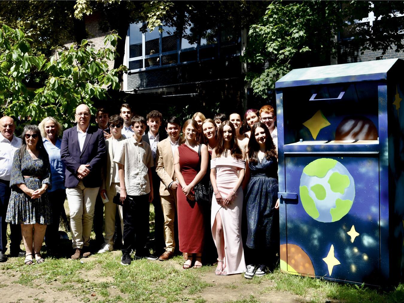 Der Öffentlichkeit präsentiert wurde der wunderschön gestaltete Altkleidercontainer von den Künstler*innen in wunderschönen Roben am Tag der Zeugnisausgabe der zehnten Klassen des Montessorizentrums Niederrhein|Privaten Realschule in Rheinberg-Borth. Mit dabei waren (v. l.) Schulleiter Johannes Munkes, Kunstlehrerin Edith Beck-Kowolik, DLB-Leiterin Elke Lasnig und DLB-Betriebsleiter|Baudezernent der Stadt Rheinberg Stephan Pfeffer. Foto: Stadt Rheinberg