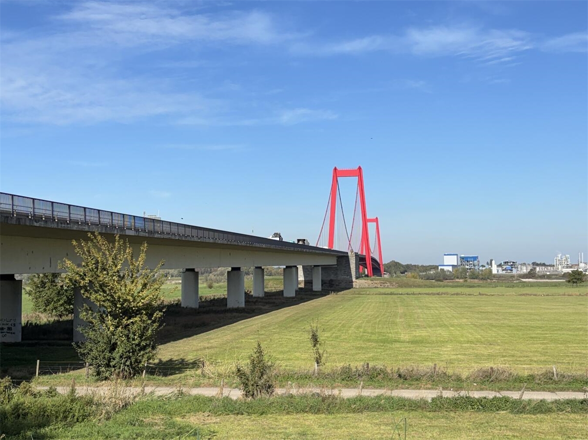 Oraniendeich bei Emmericher Rheinbrücke, Station des Projekts „Hochwasser verbindet“, Landschaft mit Rhein und Brücke. Foto von Gérard Weck.