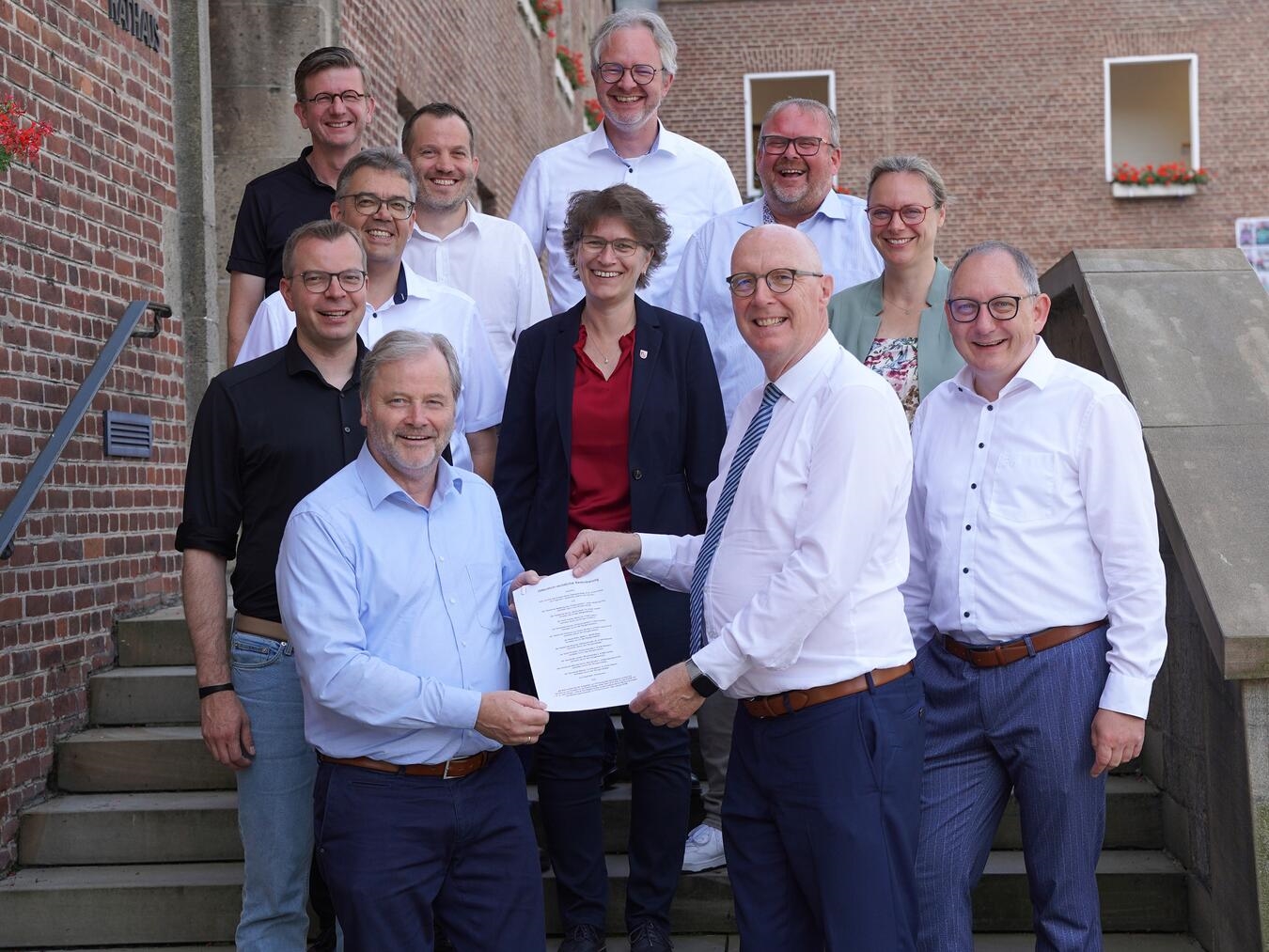 Der Rechtsanspruch auf den Offenen Ganztag wird vor Ort in den Kommunen geregelt: Im Rahmen der Konferenz der Hauptverwaltungsbeamten in Emmerich am Rhein unterzeichneten Landrat Christoph Gerwers (r. vorne) und die Bürgermeister der Kommunen, für die der Kreis Kleve die Aufgabe des Jugendamts stellt, die entsprechende öffentlich-rechtliche Vereinbarung. Foto: Stadt Emmerich am Rhein