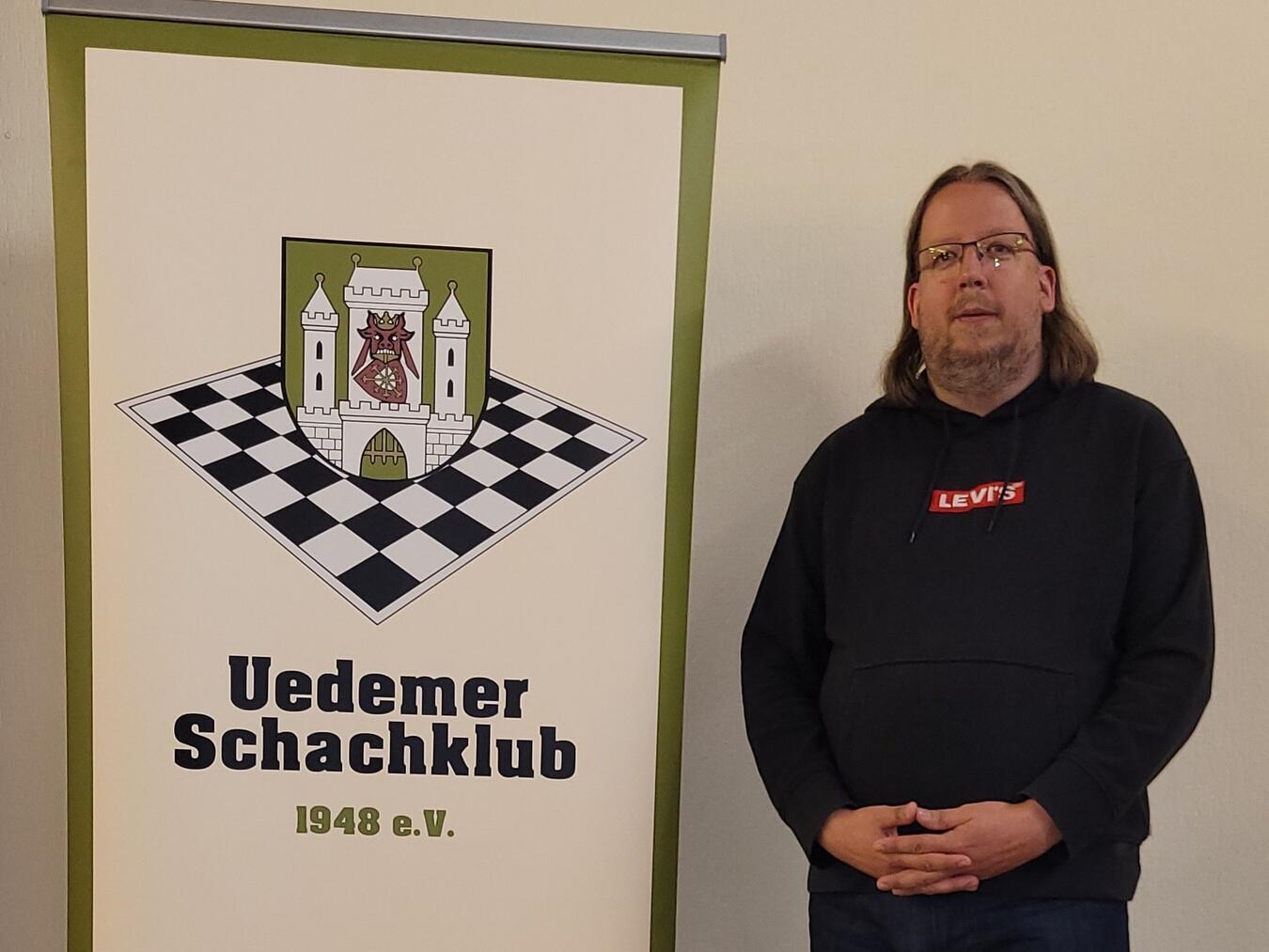 "Sven Gerrits, wiedergewählter Vorsitzender, lächelnd im Anzug"