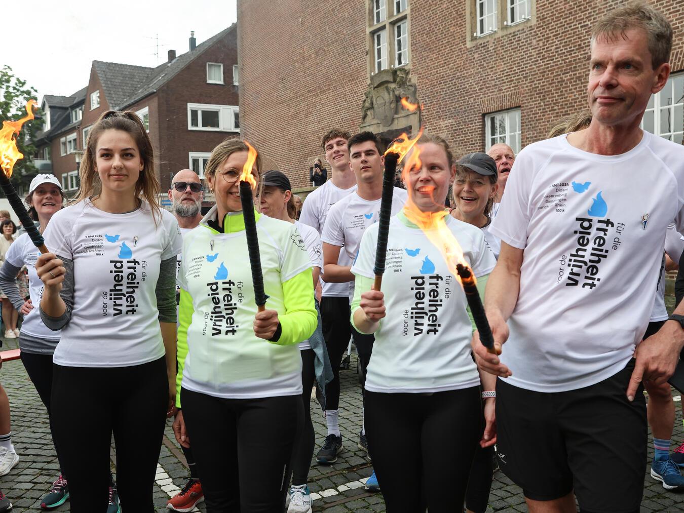 Deutsche und niederländische Läufer haben im vergangenen Jahr das Freiheitsfeuer bis zum Emmericher Rathaus getragen. Foto: Sabine Stein