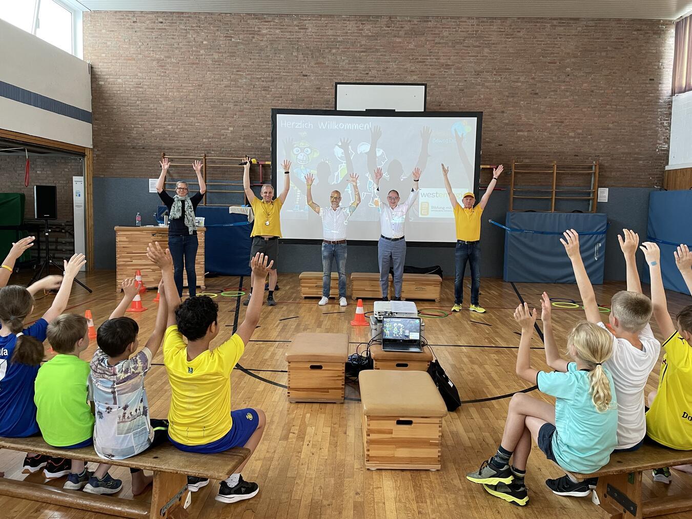 Die 57 Schüler der St. Quirinus Grundschule vertieften im Rahmen von „3malE Beweg Dich fit“ spielerisch ihr Wissen für ein nachhaltiges Leben. Britta Koltermann (Schulleiterin), Dirk Krämer (Westenergie-Kommunalmanager) und Bürgermeister Sebastian Hense (v.l.)  unterstützten die Kinder während der Veranstaltung. Foto: Westenergie AG