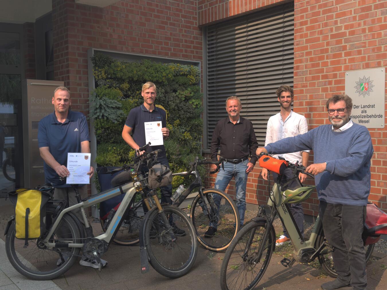 Die Alpener Stadtradel-Bestplatzierten Thomas Hommen und Josef Gietmann sowie Bürgermeister Thomas Ahls, Klimaschutzmanager Alexander Piegenschke und der zweite stellvertretende Bürgermeister Peter Nienhaus (v.l.) bei der Übergbe der Urkunden. Foto: Gemeinde Alpen