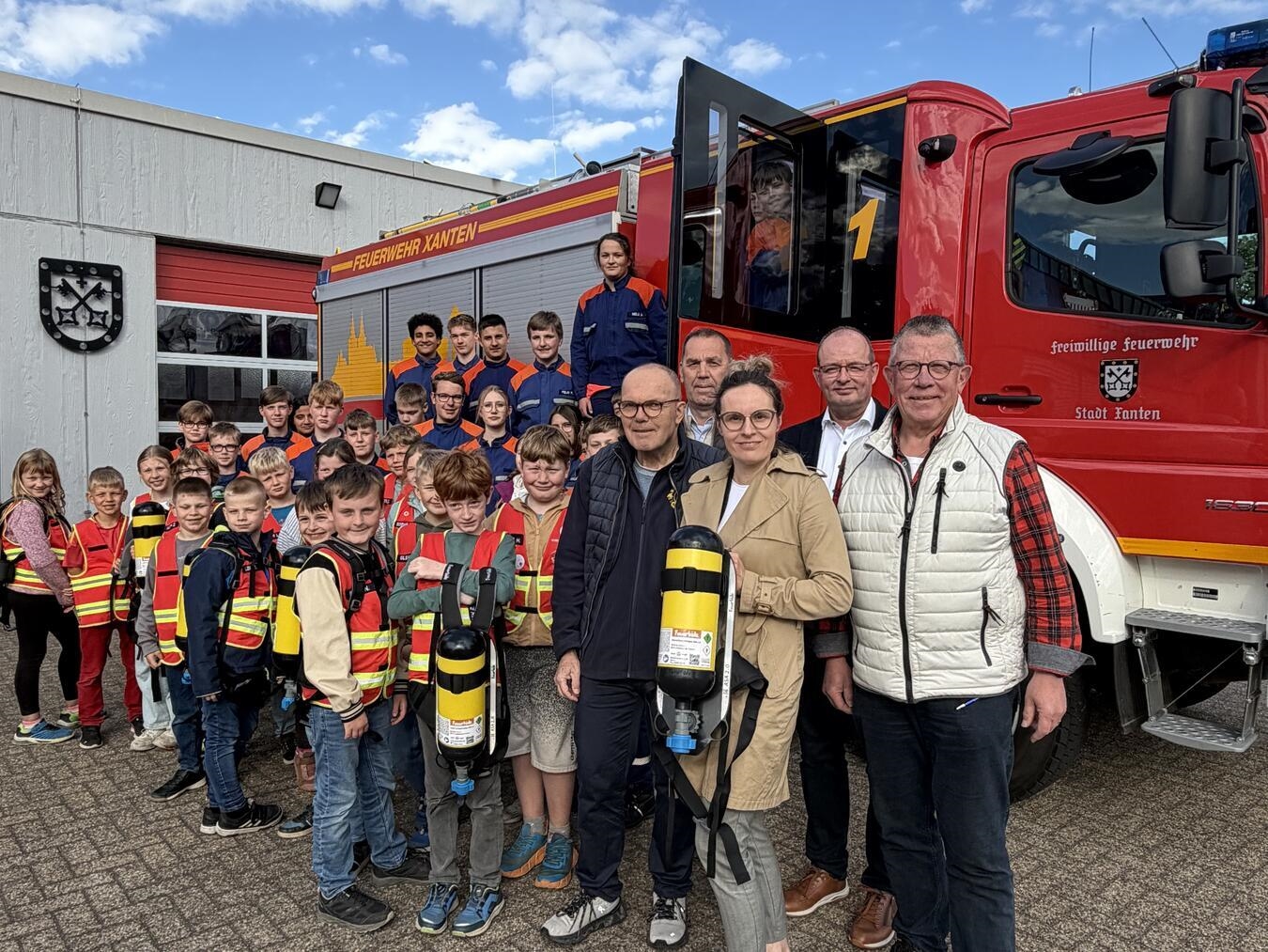Die Atemschutzflaschen-Attrappen wurden an die Kinder- und Jugendfeuerwehr übergeben. Auch die Sponsoren waren dabei. Foto: Volksbank
