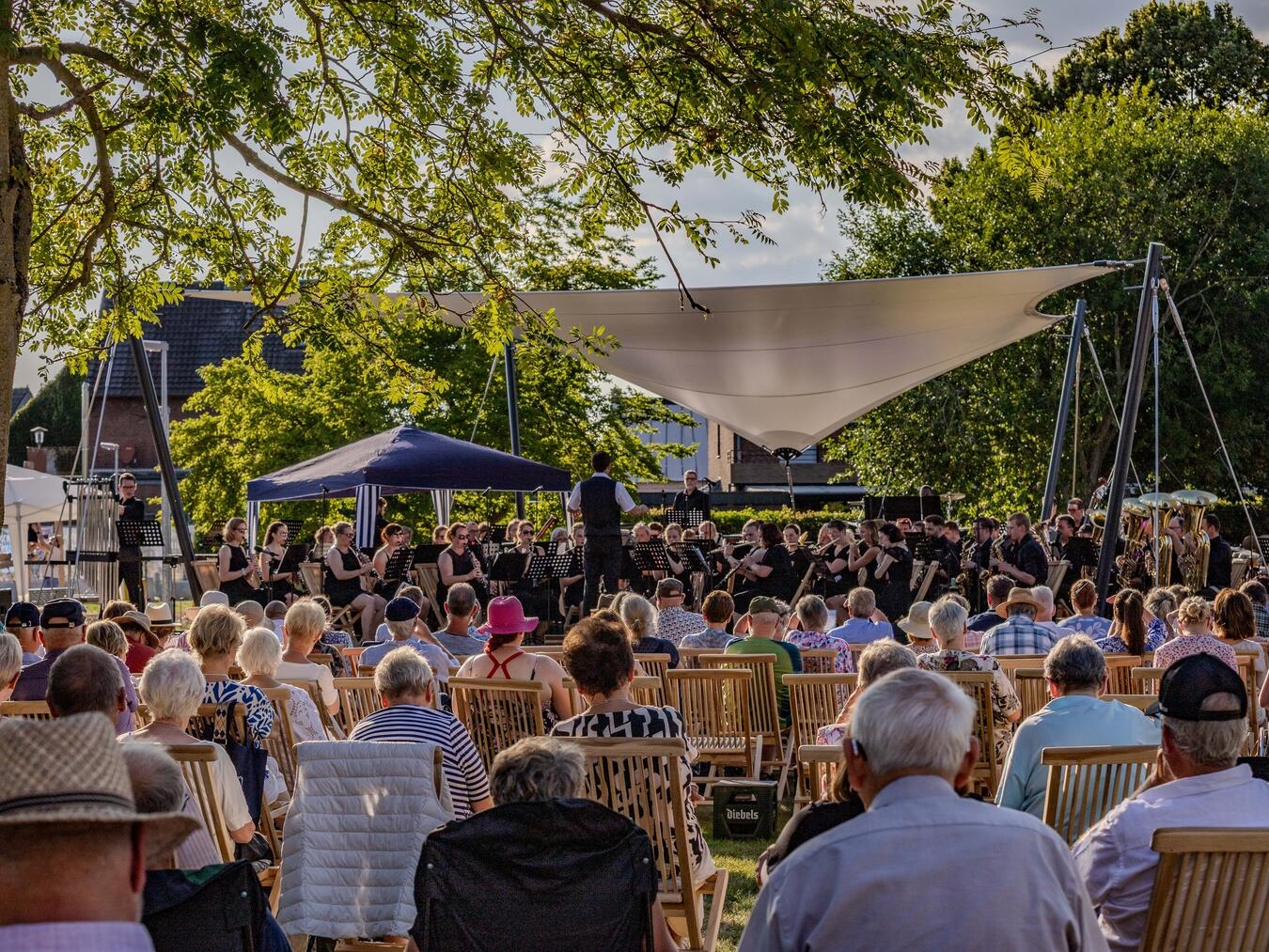 "Sinfonische Blasmusik im Bürgerpark: Konzertbesucher genießen Filmmusik und Solowerke unter freiem Himmel."