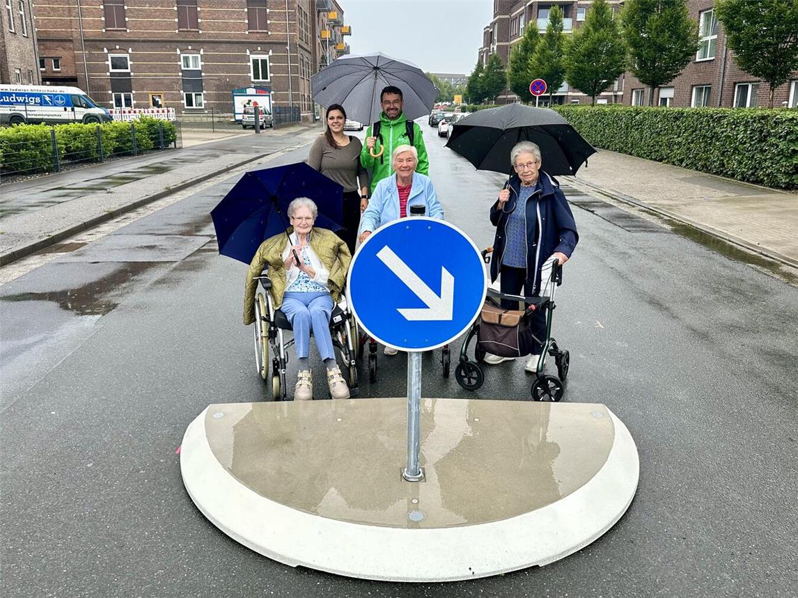 Die Bewohner des Pflegeheims Clever Stolz freuen sich mit Pflegedienstleitung Vanessa Kamps (hinten links) und SOS-Quartiersmanager Michael Gesikiewicz, dass sie nun sicherer die stark befahrene Van-den-Bergh-Straße überqueren können. Foto: SOS-Kinderdorf Niederrhein / Katrin Wißen