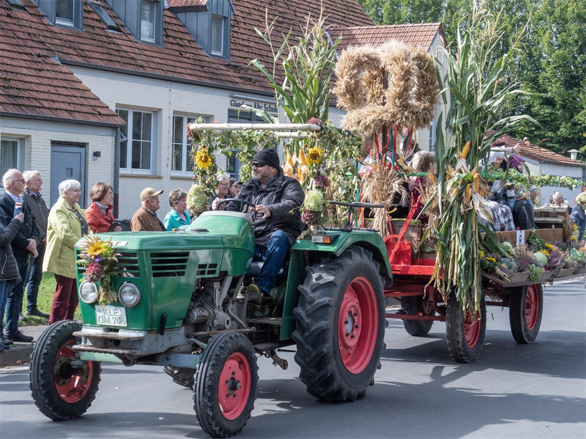 "Bunt geschmückte Erntewagen ziehen durch Dorfstraße beim Erntedankfest, fotografiert von Gerhard Seybert"