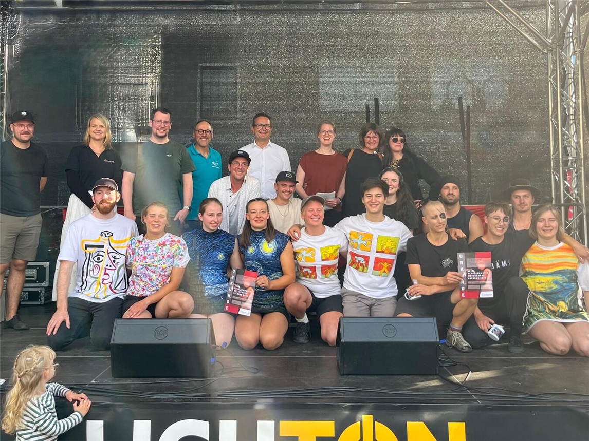 Die diesjährigen Gewinner der Straßenmaler-Kategorien zusammen mit Bürgermeister Sven Kaiser (hintere Reihe, 4.v.l.) und Rainer Niersmann (hinten, 2.v.l. , Leiter des Tourismus- und Kulturbüros der Stadt Geldern). Foto: Stadt Geldern 