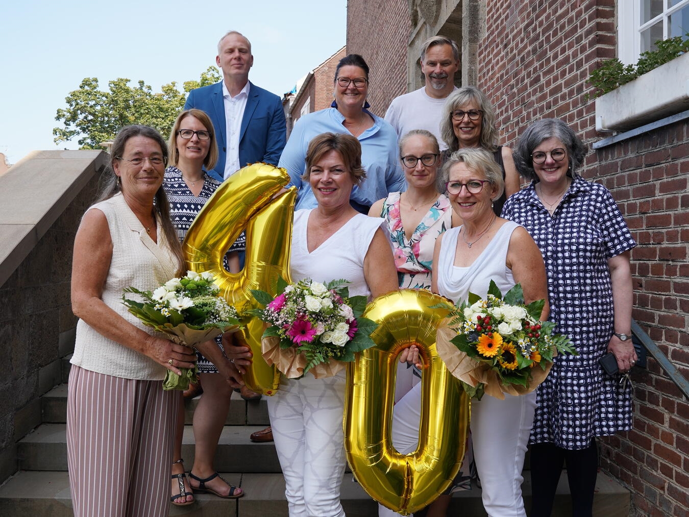 Gruppenfoto der Jubilarinnen Andrea Keulertz, Nicole Jansen, Steffi Winnands und Kolleg:innen der Stadt Emmerich bei einer Feier.