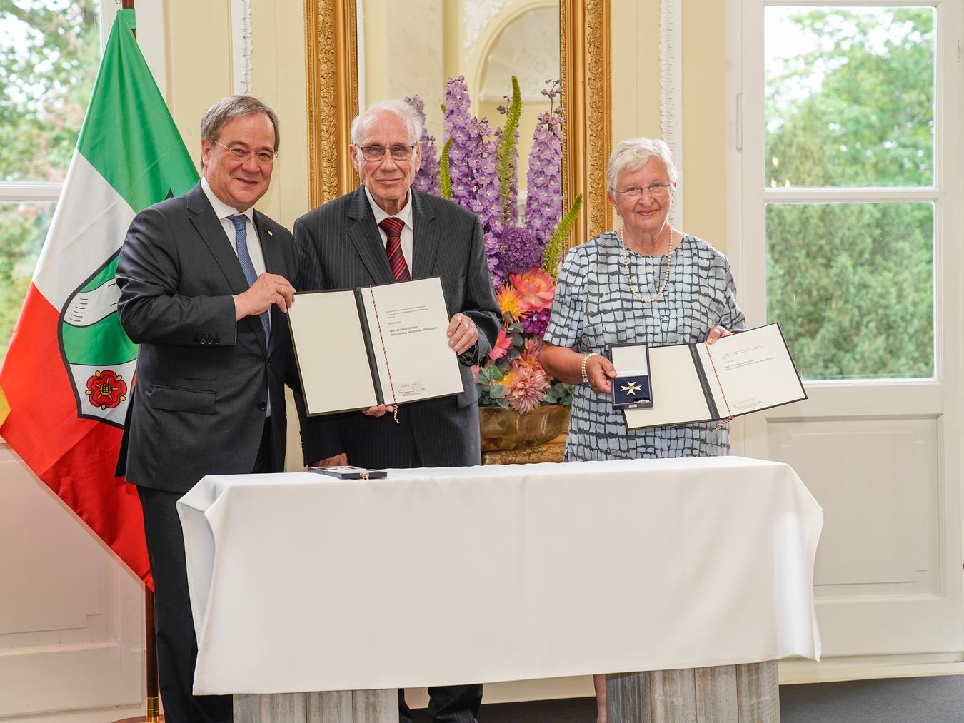 Die Eheleute Heribert (m.) und Ursula Hölz (r.) unterstützen seit den 1990er Jahren hilfsbedürftige Menschen und verschiedene Projekte in Bosnien. Dafür verlieh ihnen vor einem Jahr der damalige NRW-Ministerpräsdent Armin Laschet (l.) den Landesverdienstorden. Foto: Land NRW/Günther Ortmann