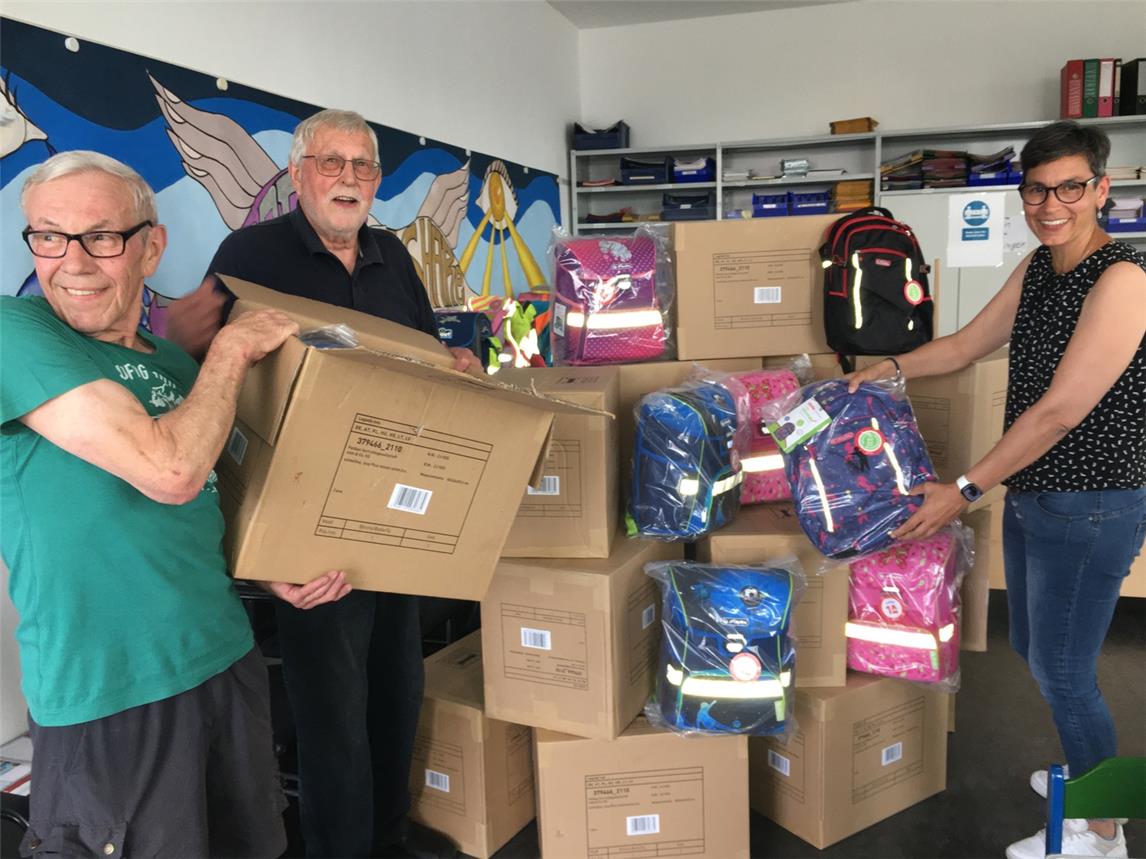 Die ehrenamtlichen Helfer im Schulmaterialmagazin der Tafel Geldern packen die neuen Tornister für die Erstklässler aus (v. l. n. r.): Werner Bocksteger, Alfred Mersch (Vorsitzender) und Bettina Link.Foto: Tafel Geldern