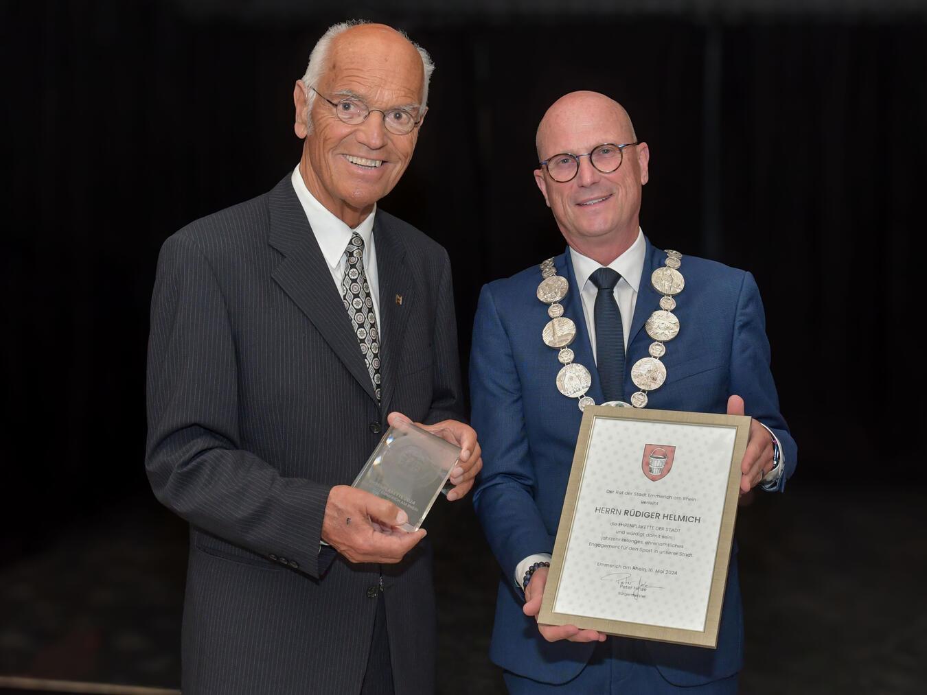 Die Ehrenplakette der Stadt Emmerich hat Bürgermeister Peter Hinze (r.) im Namen des Rates an Rüdiger Helmich (l.) verliehen. Damit würdigt die Stadt dessen ehrenamtliche Verdienste um den Sport. NN-Foto: G. Seybert