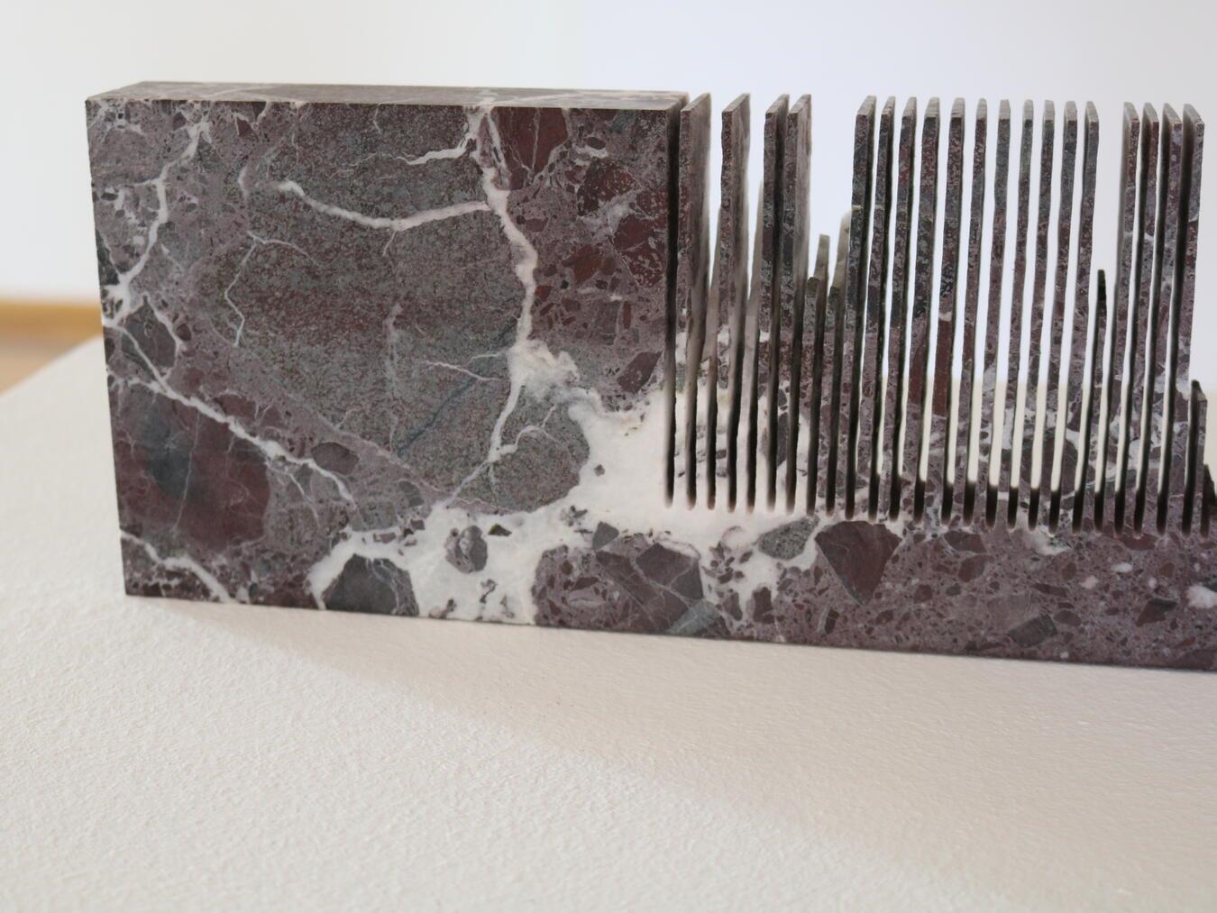 Die Einschlüsse im Marmor sorgen für das zufällige Farbergebnis beim Prozess des Sägens. Der Block ist als Referenz mit im Raum positioniert.