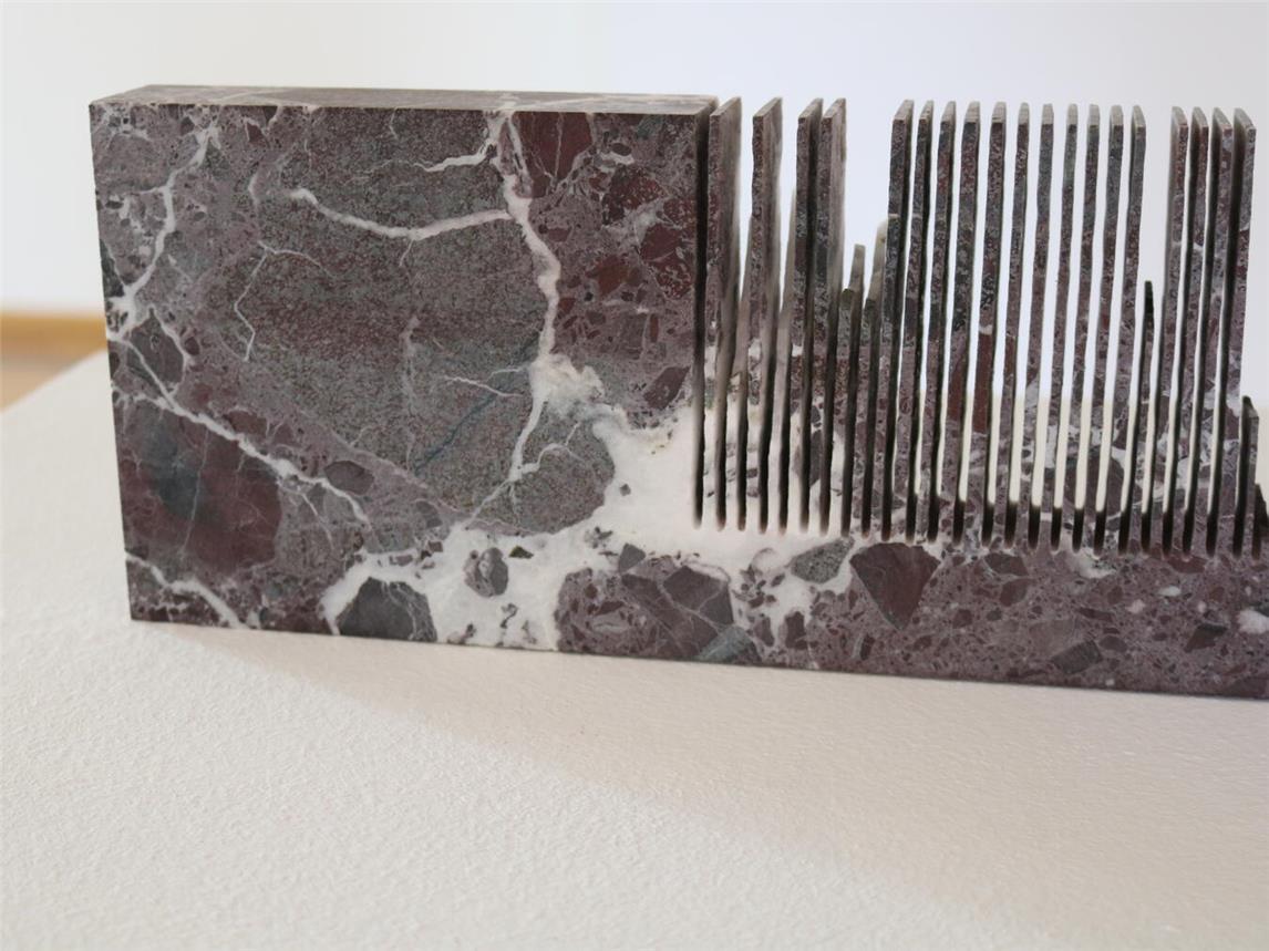 Die Einschlüsse im Marmor sorgen für das zufällige Farbergebnis beim Prozess des Sägens. Der Block ist als Referenz mit im Raum positioniert.