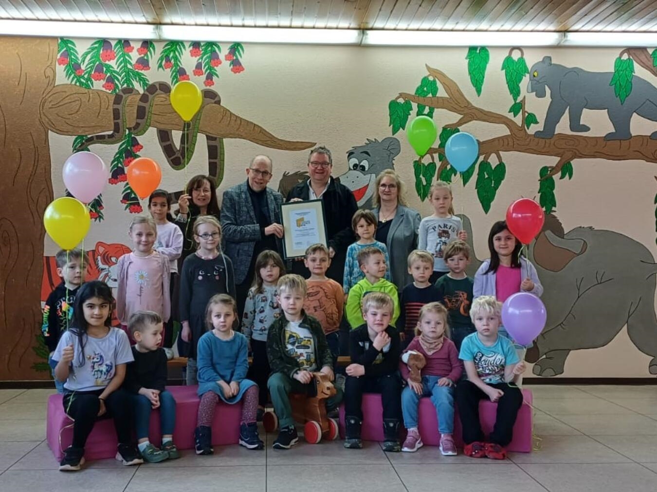 Die Erzieherin Christiane Frost, Pastor Klaus Martin Niesmann, Bürgermeister Georg Koenen, die Kindergartenleitung Daniela Klose (v.l.)und die Kinder freuen sich über Rezertifizierung. Foto: privat