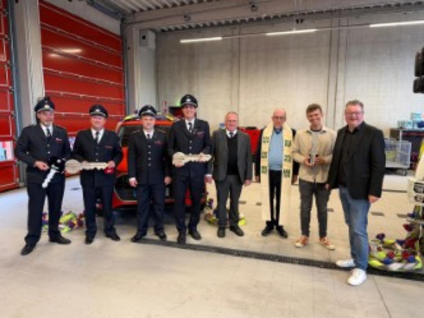 Neue Feuerwehrfahrzeuge in Weeze; Feuerwehrleute stehen stolz neben modernen Einsatzfahrzeugen. Foto: Guido Gleißner