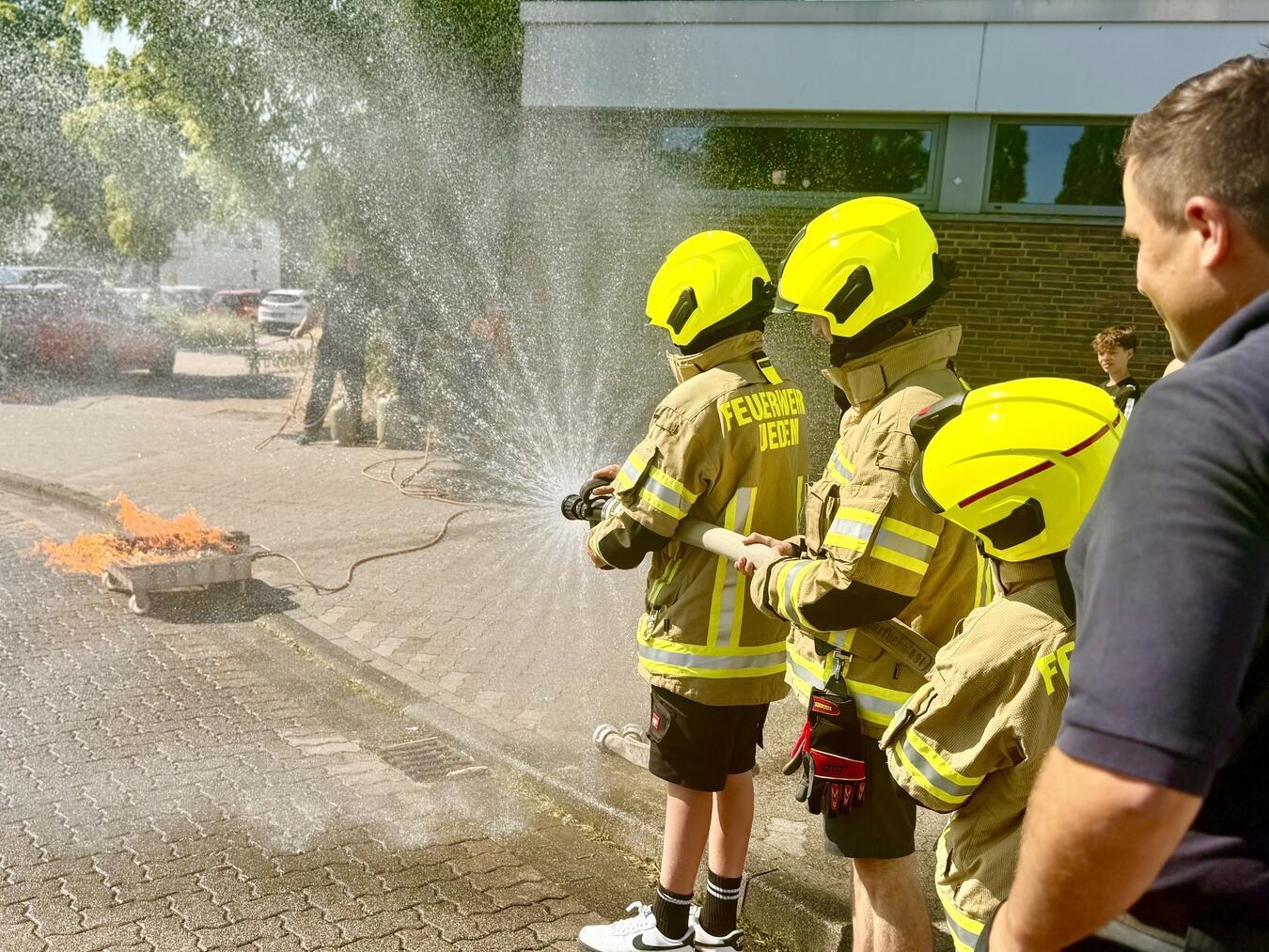 "Freiwillige Feuerwehr Uedem zeigt Schülern Einsatzfahrzeug und Ausrüstung bei spannender Vorführung"