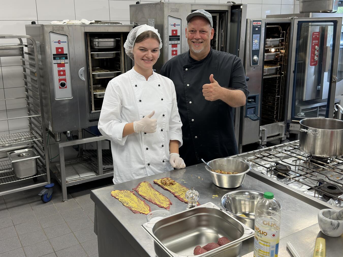 Die Gocherin Lavinia Ricken hat ihre Ausbildung in der Küche der Schulmensa in der Wallfahrtsstadt Kevelaer absolviert und erfolgreich als Innungsbeste abgeschlossen. Ihr Anleiter Thomas Wanders freut sich mit ihr über das hervorragende Ergebnis.Foto: SOS-Kinderdorf Niederrhein / Foto: Katrin Wißen