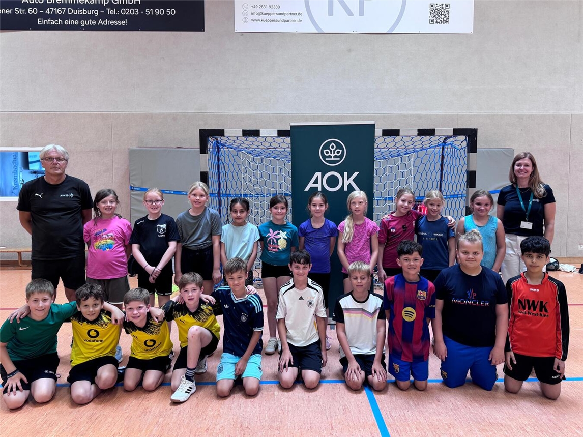 "Grundschulkinder Issum im Training mit Ex-Profis, lachend auf Sportplatz"