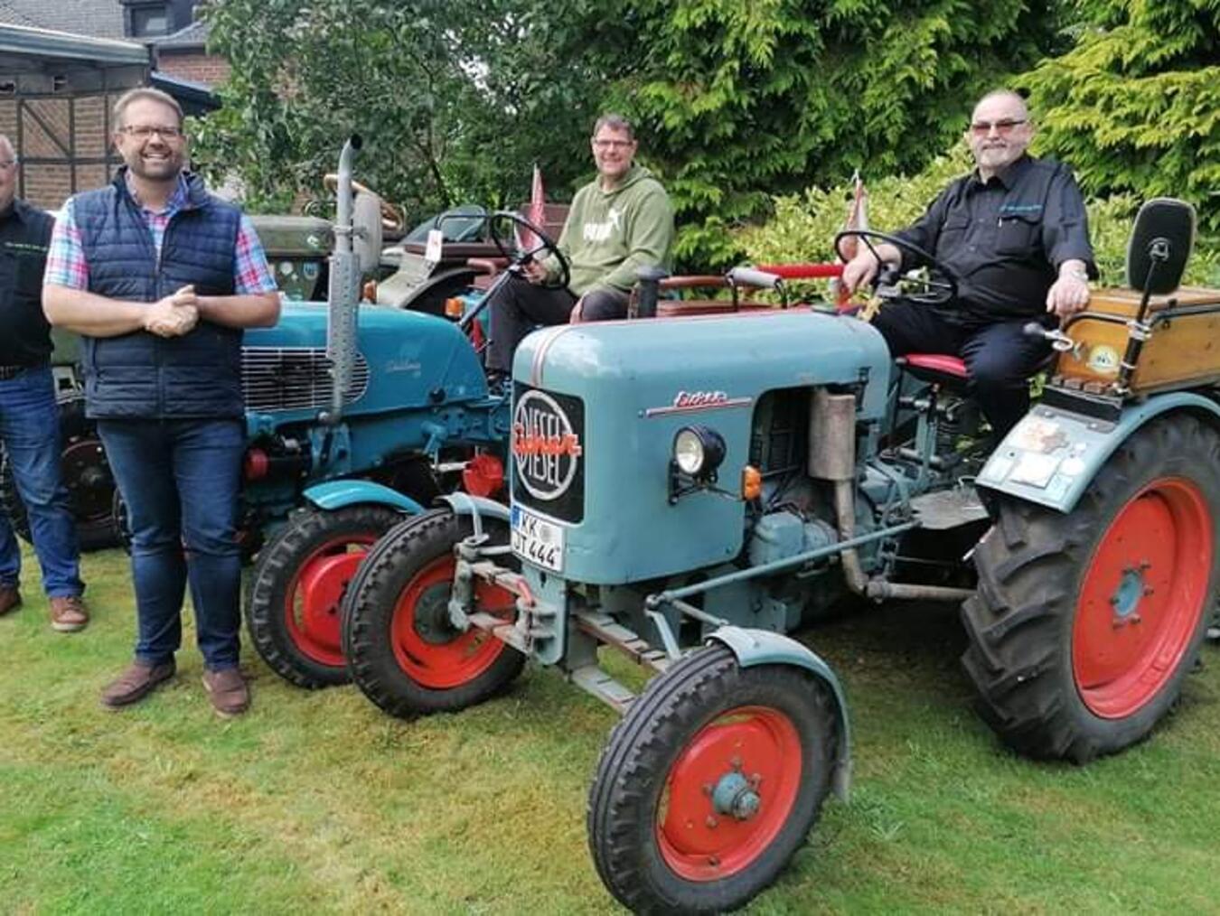 Die Jakobsmuschel an seinem Trecker begleitet Johannes Thodam (r.) auf allen Strecken. André Dahlke und Gerd Lemkens freuen sich mit Dr. Bastian Rütten (v.l.) auf die zweite Wallfahrt der Oldtimer-Trecker nach Kevelaer. Foto: Bischöfliche Pressestelle / Christian Breuer