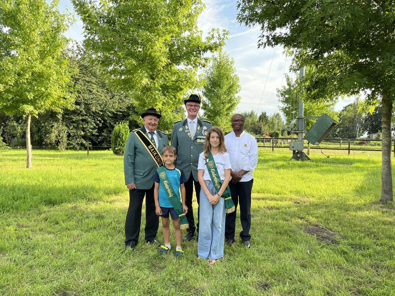 Die jungen Regenten in Elten: Das Kinderkönigspaar Kalle Berndsen und Ismihana Islamagic mit Franz Trummer (Maikönig), Henry Slagmeulen (Brudermeister), Égide Muziazia (Präses, hinten v. l.). Foto: privat