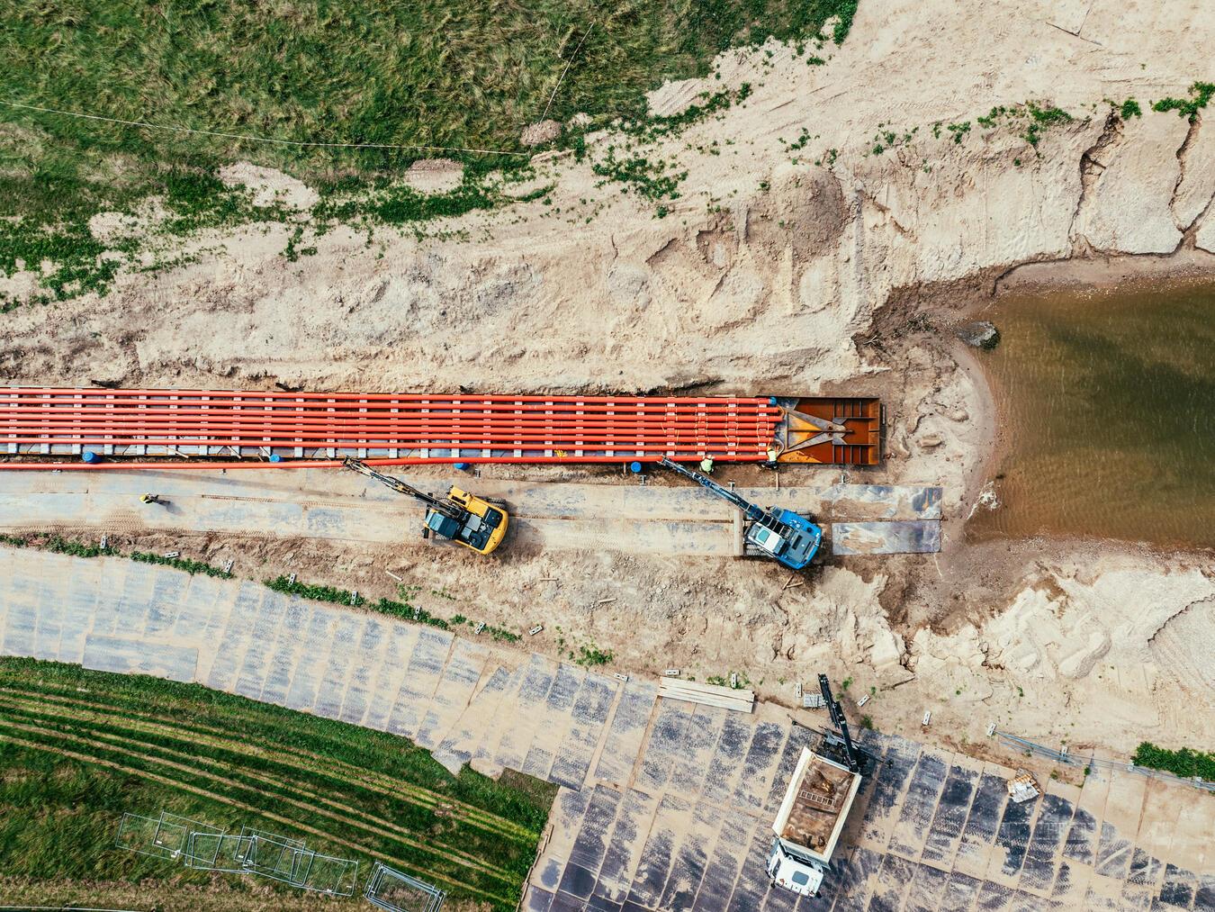 Die Kabelschutzrohre wurden mithilfe eines Düker-Schlittens in den Rhein gezogen. Foto: Hülskens Wasserbau