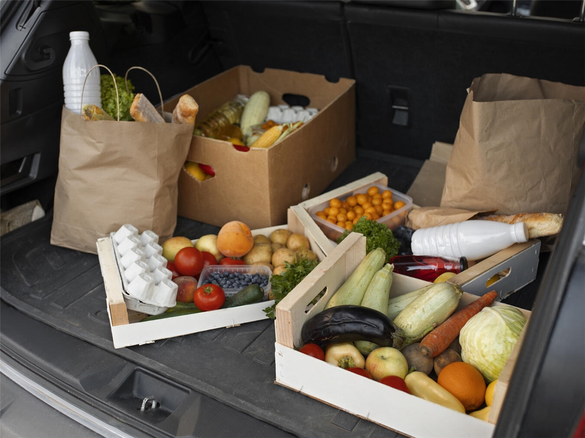 "Ehrenamtliche Fahrer der Kevelaerer Tafel vor einem Lieferfahrzeug, lächelnd und hilfsbereit."