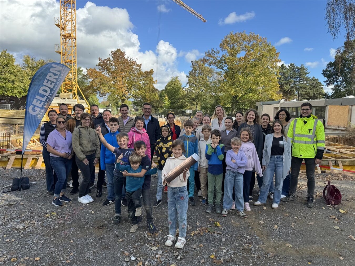 Kinder der Veerter St.-Martini-Schule versenken Zeitkapsel mit Erinnerungsstücken in Baugrube. Foto: Stadt Geldern/Leeder